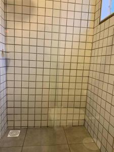 特雷斯拉瓜斯Studio Standard l AO LADO SHOPPING的浴室设有白色瓷砖墙壁和窗户。