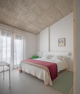 费雷列斯Ses Sucreres Small & Slow Hotel的白色卧室配有一张带红色毯子的大床