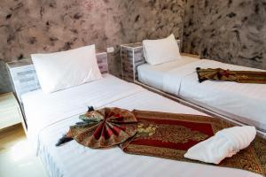 Buengngarm Resort的床上托盘的客房内的两张床