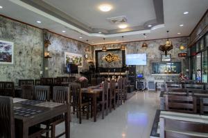 Buengngarm Resort的一间带木桌椅的餐厅和一间酒吧