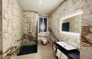 萨拉热窝Apartments Museum的大理石浴室配有水槽和淋浴