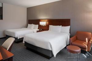 长滩长滩机场万怡酒店的酒店客房,配有两张床和椅子