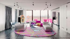 柏林柏灵纽沃酒店的客厅配有粉红色的椅子和地毯