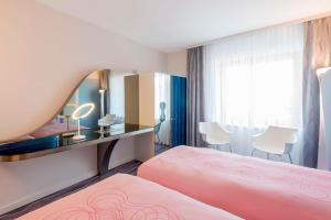柏林柏灵纽沃酒店的酒店客房配有粉红色的床和镜子