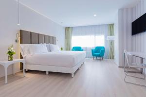 普埃布拉NH Puebla FINSA的白色卧室配有床和桌椅