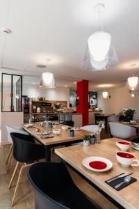 贝诺代Le Cornouaille Hotel & Spa的厨房以及带桌椅的用餐室。