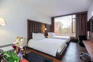 波哥大波哥大安蒂诺皇家精选NH酒店的酒店客房设有两张床和大窗户。