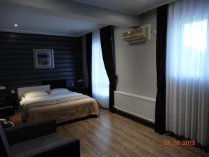 Razgrad米莫扎酒店的一间卧室设有一张床和一个窗口