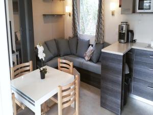 瓦尔拉普拉日mobil home confort premium的厨房以及带沙发和桌子的客厅。