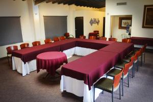 恩塞纳达港波萨达埃雷伊索尔酒店的一间大型会议室,配有紫色的桌子和椅子