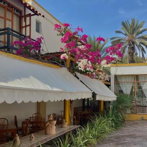 伊察西扎旅馆的一座配有桌椅和粉红色鲜花的建筑