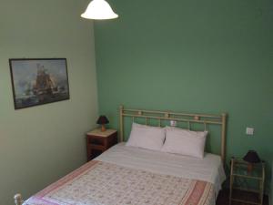 Ágios RókkosCASA KIRKI的卧室配有一张床,墙上挂着一幅画