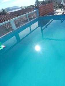 帕拉蒂Canto do mar的一个空的游泳池,有栅栏和蓝色的水