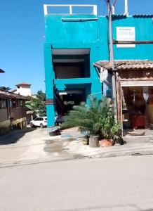 帕拉蒂Canto do mar的一座蓝色的建筑,前面有棕榈树