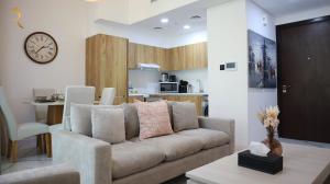 阿布扎比Glen 2BR Duplex Masdar city的带沙发的客厅和厨房
