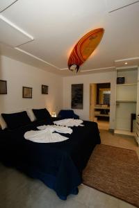 阿拉亚尔达茹达Aqui Bate a Brisa Pousada的一间卧室设有一张床铺,天花板上设有冲浪板