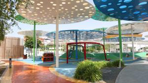阿布扎比Glen 2BR Duplex Masdar city的公园内一个带遮阳伞的游乐场
