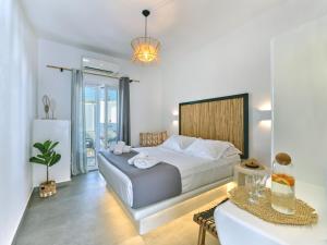 纳乌萨梅思娜独家公寓式酒店的一间卧室配有一张大床和一张桌子及四柱床