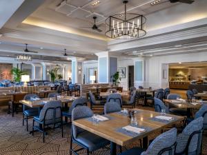 博尼塔斯普林斯Hyatt Regency Coconut Point Resort & Spa Near Naples的餐厅设有木桌和蓝色椅子