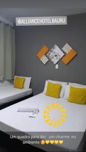 巴乌鲁Alliance Hotel的一间卧室配有两张带黄色枕头的床