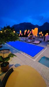 安塔利亚GÜLER BUTİK HOTEL的享有游泳池的夜间景致
