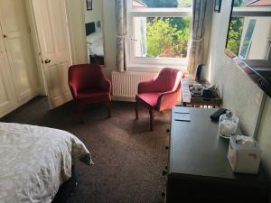 伊尔弗勒科姆瓦利屋酒店的卧室配有两把椅子、一张桌子和一张床