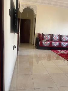 拉巴特Charmant appartement à Hassan的客厅配有红色沙发,铺有瓷砖地板。