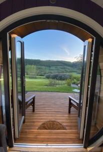 斯卡伯勒Luxury Glamping In North Yorkshire National Park & Coastal Area的通往带长凳和美景的甲板的开放式门