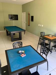 彼得罗波利斯Apartamento Hotel Itaipava Petropolis的配有乒乓球桌和椅子的房间