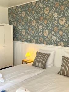 阿灵厄散库斯贝德酒店的一间卧室配有一张带花卉壁纸的床