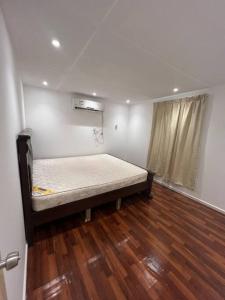 达沙Two rooms and one living room in Delma island的木地板客房的一张床位