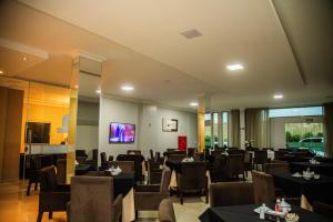 阿尔塔米拉Dallas Hotel Premium的一间在房间内配有桌椅的餐厅