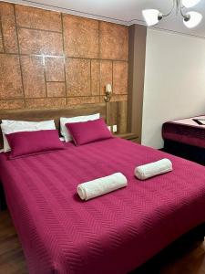 拉巴斯Hotel Esmeralda的一张红色的大床,上面有两条白色的毛巾