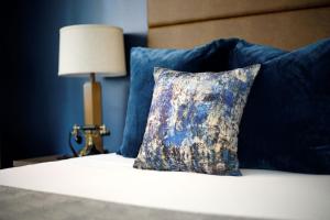 威奇托老城区酒店的床上的枕头,带蓝色枕头和灯
