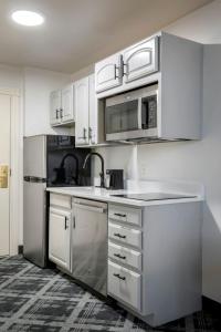 威奇托老城区酒店的厨房配有白色橱柜和不锈钢用具