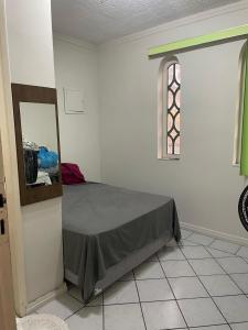 贝伦Casa Maria Toda Linda的一间卧室设有一张床、一个窗口和一面镜子