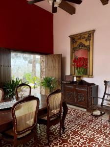 梅里达Hotel & Hostal Boutique Casa Garza的一间带桌椅和镜子的用餐室