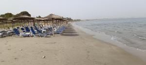 阿特米达AIR-IN Rooms with magnificent views的海滩上的一排椅子和遮阳伞