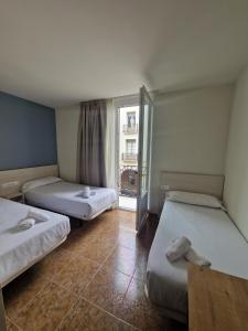 韦斯卡鲁加卡旅馆的带窗户的客房内的两张床