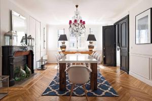 巴黎205sm luxury and design flat at Paris Montmartre的一间带桌子和吊灯的用餐室