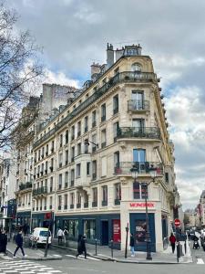 巴黎205sm luxury and design flat at Paris Montmartre的一条城市街道上一座大型建筑,人们穿过街道