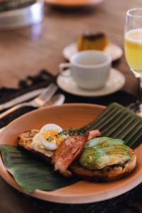 托兰克索Casa Baiana Pousada & Aconchego的包括鸡蛋培根和烤面包的早餐食品
