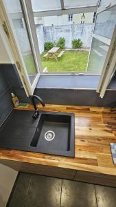 布雷斯特Maisonnette tout confort.的一个小房子里的一个厨房水槽,有窗户