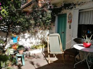 马德里Casita的一个带椅子和桌子的庭院和一扇绿门