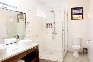 圣伊格纳西奥The West House Boutique Hotel的一间带两个水槽和玻璃淋浴间的浴室
