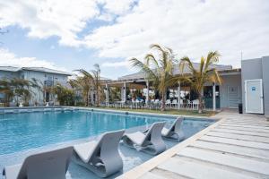 蓬塔查梅Sanctuary by Playa Caracol Residences的一座带躺椅的游泳池位于大楼旁