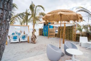 蓬塔查梅Sanctuary by Playa Caracol Residences的海滩上带椅子和遮阳伞的度假村