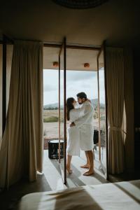 El PorvenirEqu Hotel de Tierra的镜子前的一名新娘和新郎拥抱