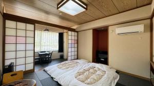 由布市Yufuin Akarinoyado的卧室中间设有一张床
