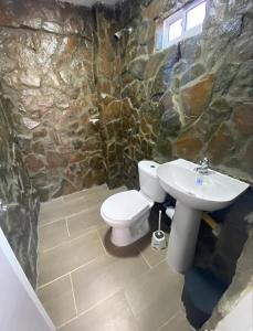 塔甘加Apartahotel的石质浴室设有卫生间和水槽